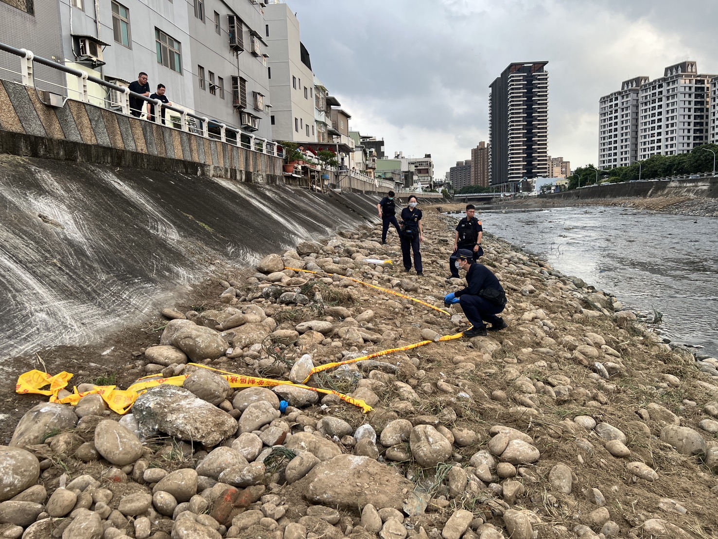 ▲桃園市桃園區警方接獲通報指南崁溪河床有未爆彈，當即封鎖現場並驅離現場圍觀民眾。（翻攝畫面）