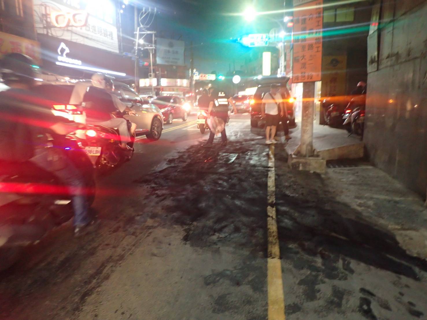 ▲桃園市八德區和平路,昨(13)日18時許路面出現大片油漬,造成1名女騎士慘摔犁田。(翻攝畫面)