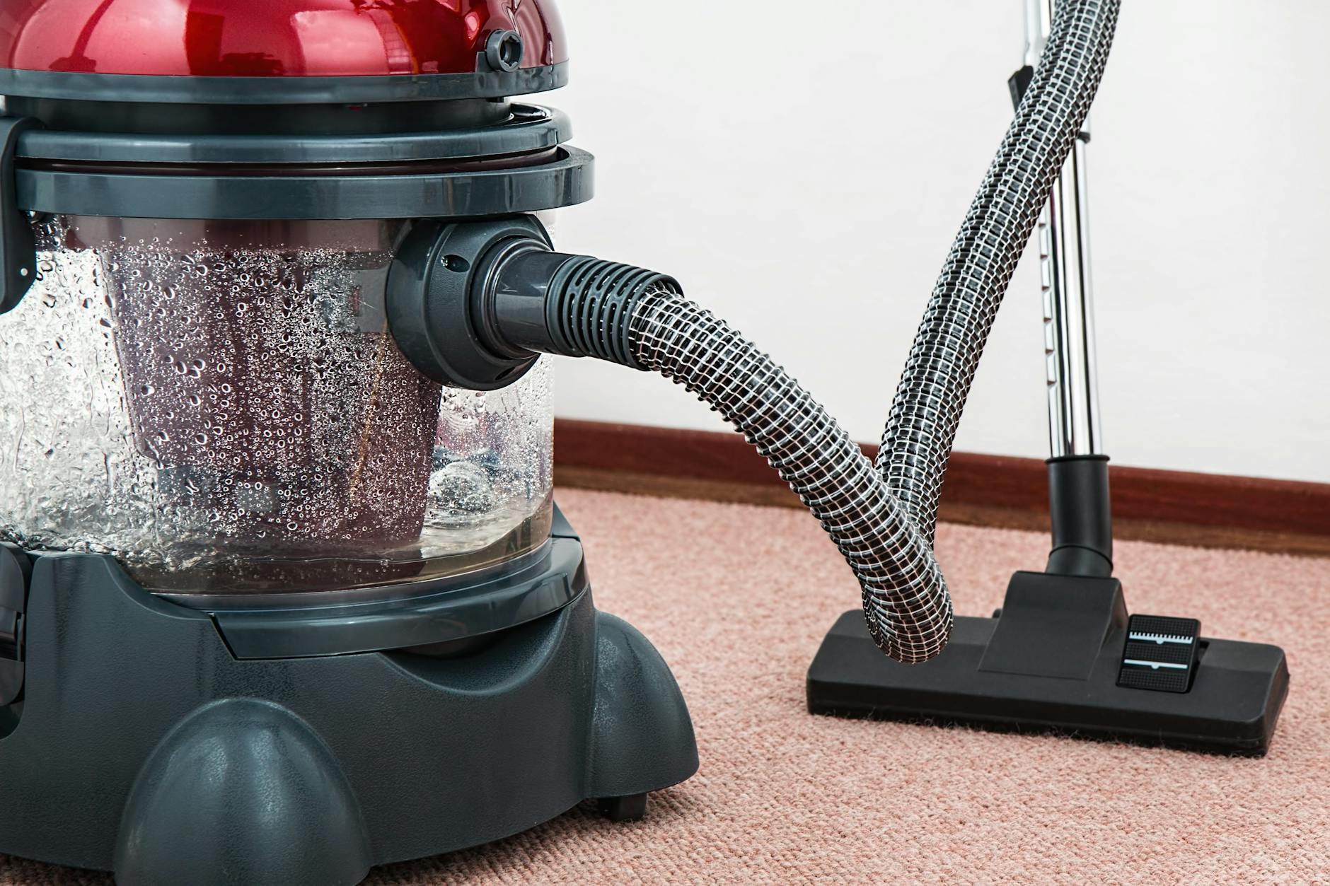 black and red canister vacuum cleaner on floor