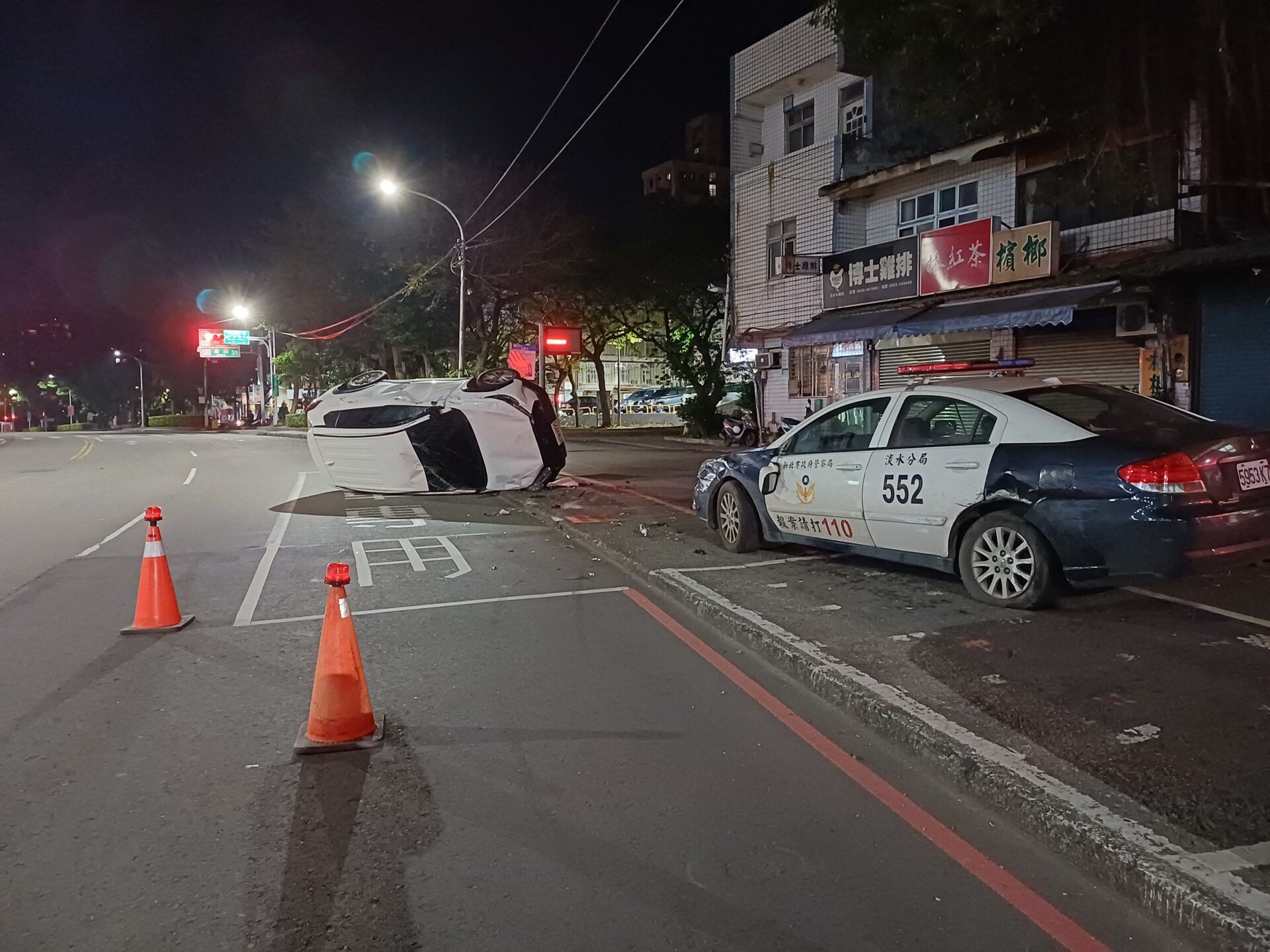 ▲新北市淡水區水碓派出所前，今（13）日2時許有車輛碰撞警車後翻覆。（翻攝畫面）